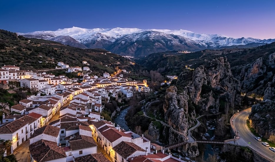 Vista espectacular del pueblo de Monachil, el río y las montañas de Sierra Nevada al fondo en Granada